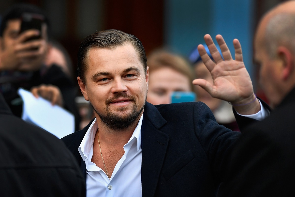 Leonardo DiCaprio la costum în timp ce face cu mâna fanilor din Scoția într-o vizită oficială din anul 2016