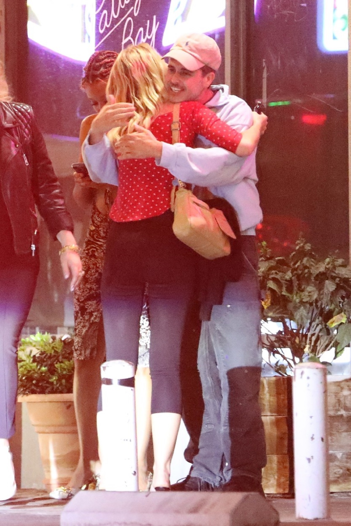 Lily-Rose Depp în timp ce se îmbrățișează cu un prieten în fața unui restaurant din Los Angeles