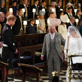 Prințul Charles îmbrăcat la costum în timp ce o conduce pe Meghan Markle la altar în ziua nunții sale cu Prințul Harry