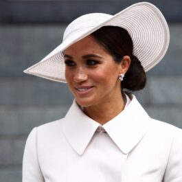 Meghan Markle într-un costum alb cu pălărie în timp ce ia parte la Jubileul de Platină al Reginei Elisabeta