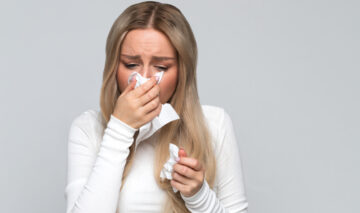 O femeie care își suflă nasul atunci când plânge