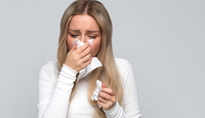 O femeie care își suflă nasul atunci când plânge