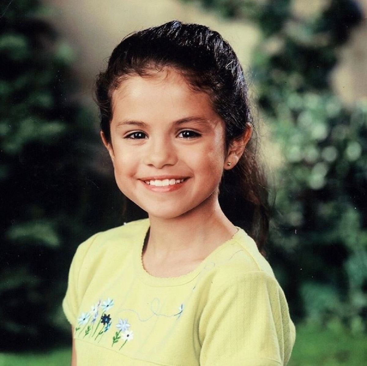 Selena Gomez într-un tricou galben într-o imaginie din copilărie