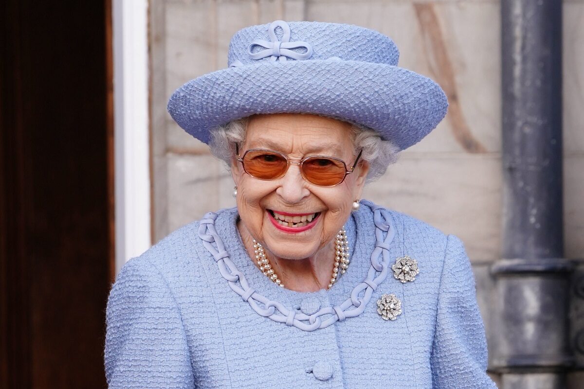 Regina Elisabeta într-un costum albastru cu pălărie în timp ce ia parte la vizita oficială din Scoția 2022
