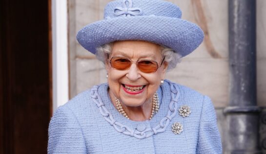 Regina Elisabeta într-un costum albastru cu pălărie în timp ce ia parte la vizita oficială din Scoția 2022