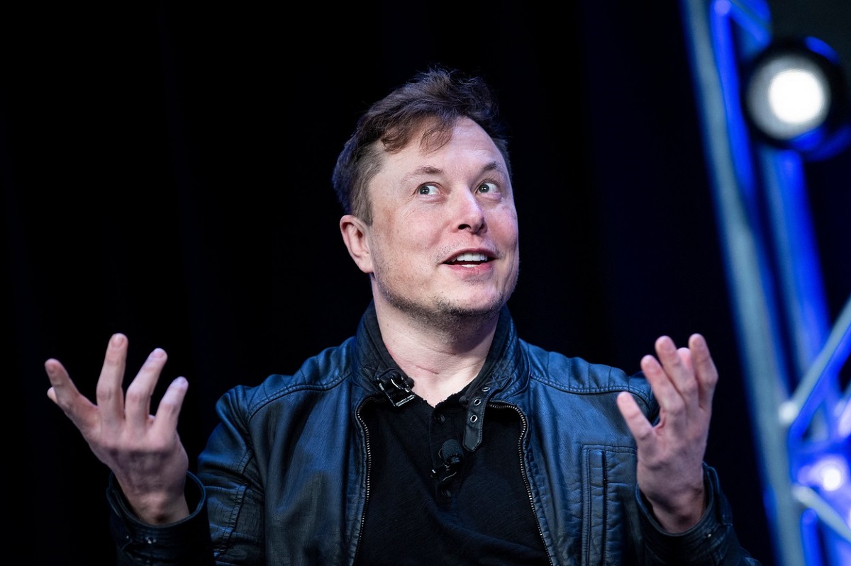 Elon Musk îmbrăcat la costum în timp ce ține o conferință de presă