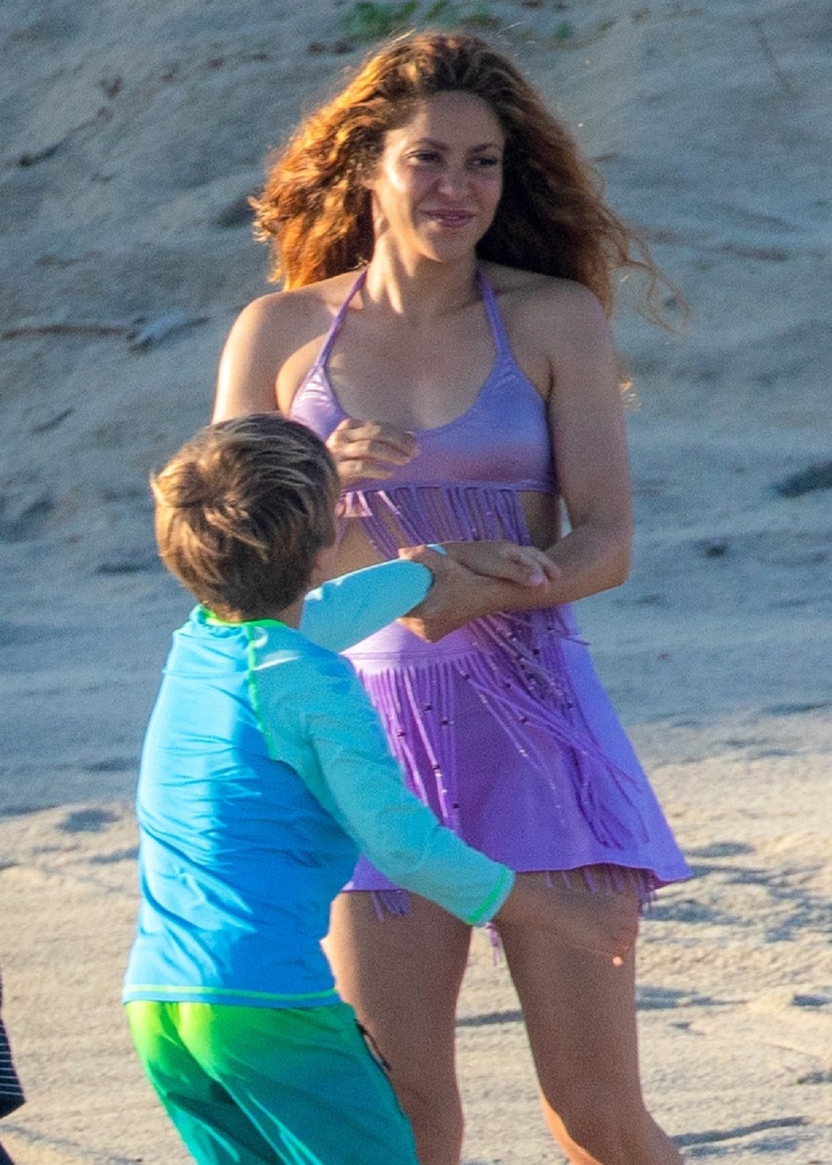 Shakira într-un costum de baie violet în timp ce se joacă pe plajă cu fiul său, Sasha