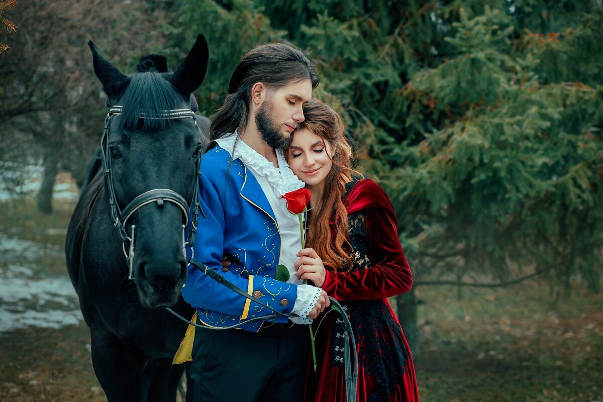 Un cuplu de îndrăgostiți alături de un cal care pozează îmbrățișați pentru a ilustra acele zodii care iubesc pasional