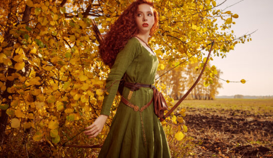 Fată frumoasă cu părul roșcat și lung se află într-o pădure în anotimpul toamna