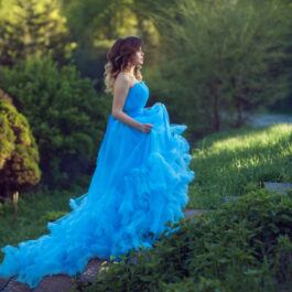 Fată frumoasă îmbrăcată într-o rochie lungă, albatră stă în pădure