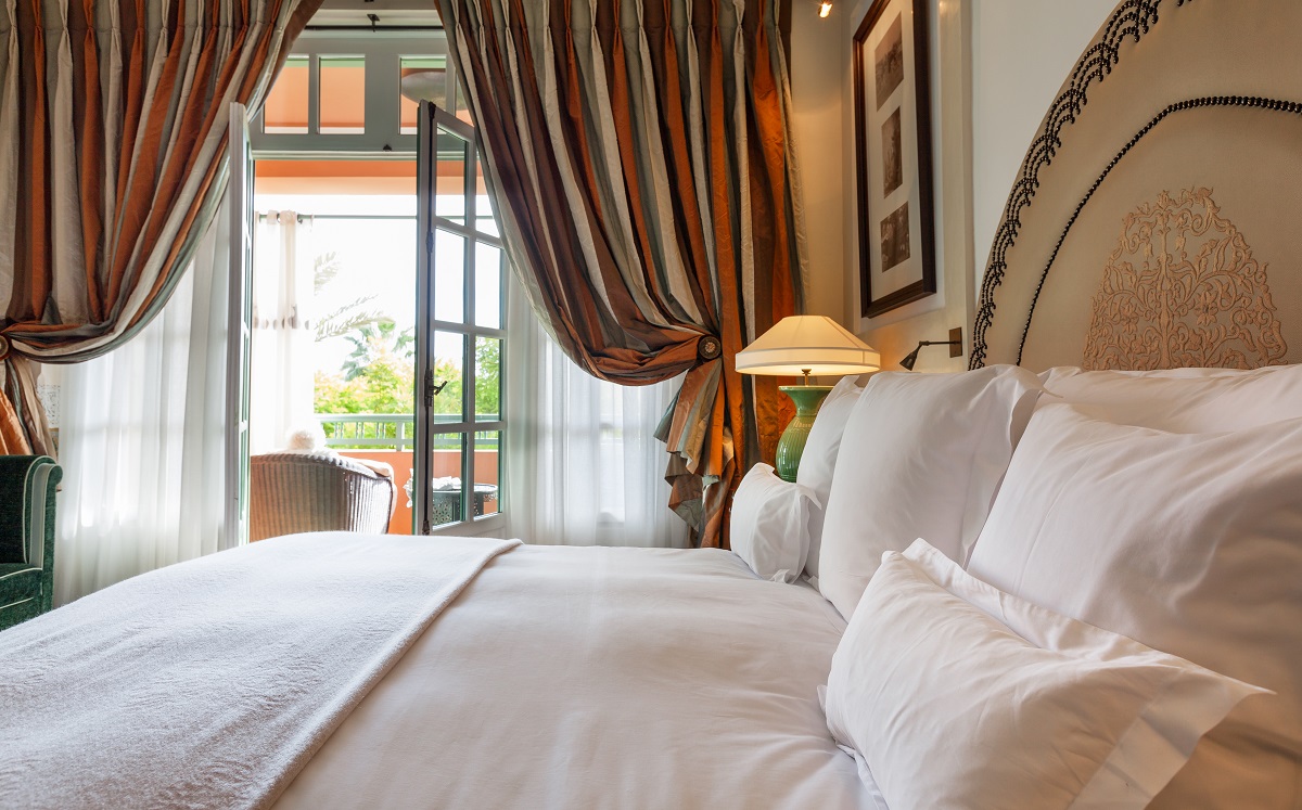 Un dormitor cu draperii maro, culoare care nu se află pe lista de culori de draperii pe care ar trebui să le eviți în dormitor
