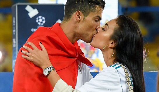 Georgina Rodriguez și Cristiano Ronaldo în timp ce se sărută la un meci de fotbal