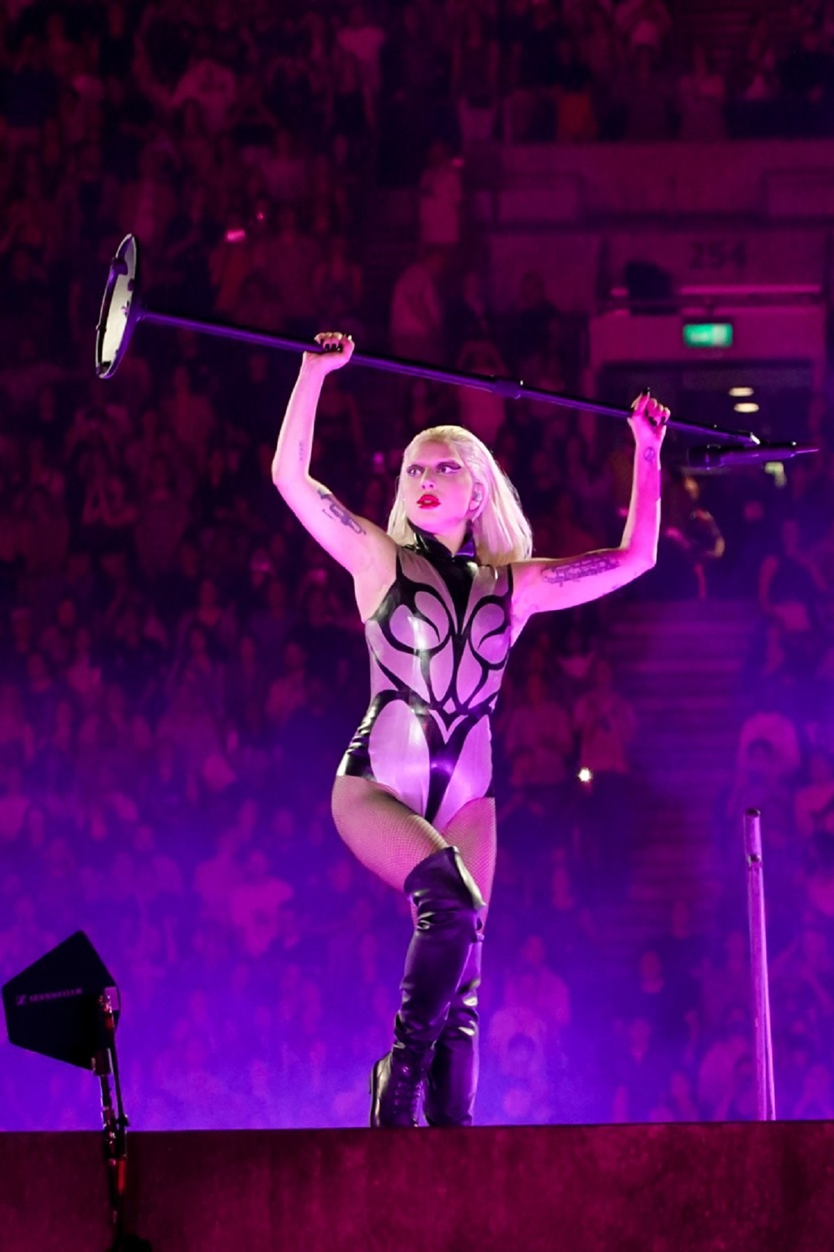 Lady Gaga într-un body gri în timp ce face spectacol pe scena din Lodnra