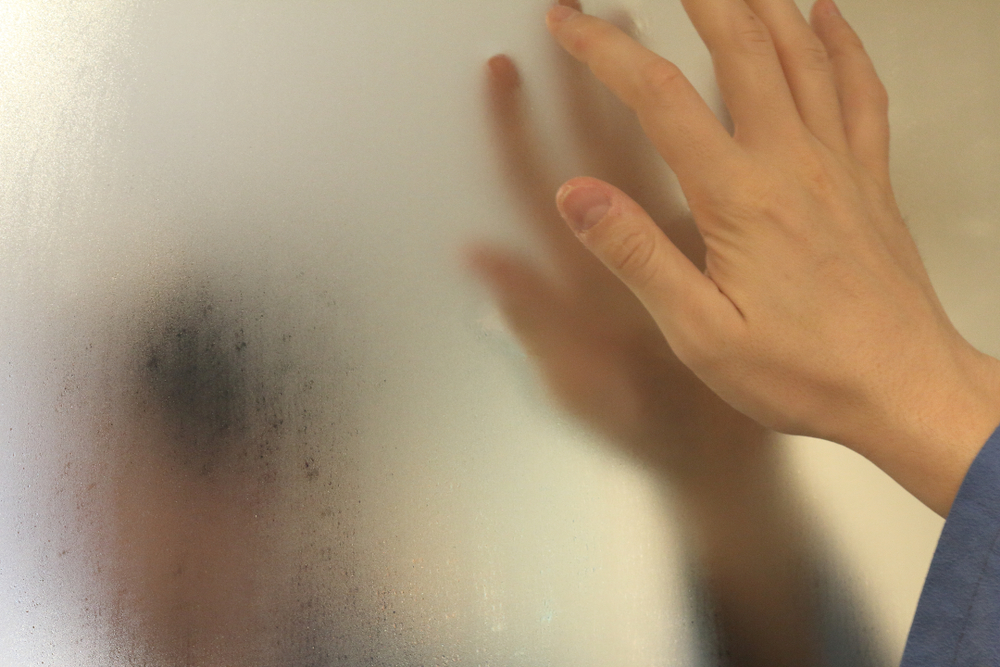 O femeie care dă cu degetul pe oglinda aburită din baie