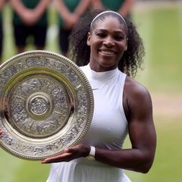 Serena Williams care a anunțat că se retrage din tenis în timp ce ține în mână trofeul de Grand Slam