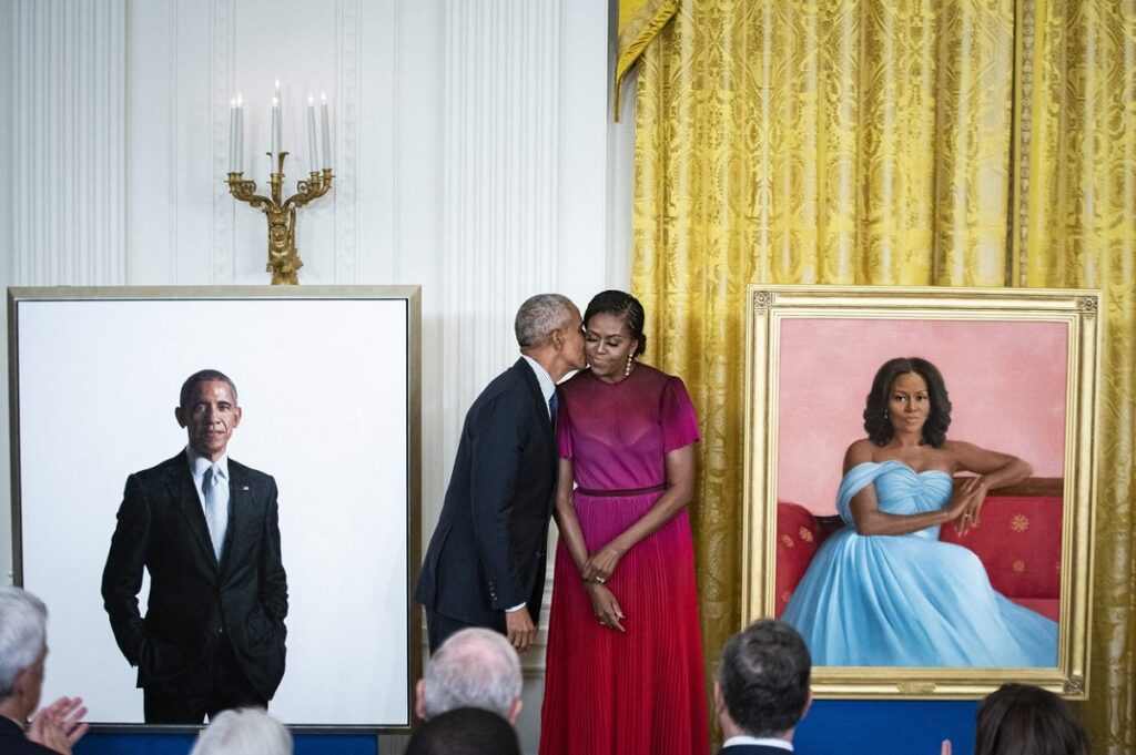 Barack și Michelle Obama în timp ce pozează alături de portretele oficiale de la Casa Albă
