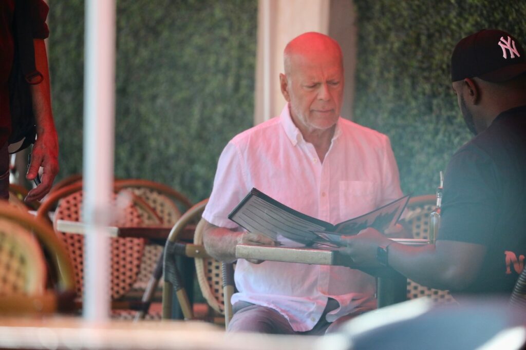 Bruce Willias, la un restaurant, în timp ce citește meniul