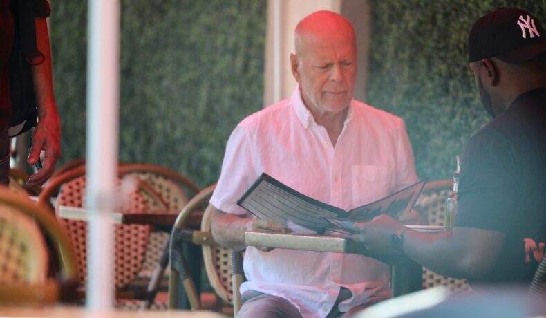 Bruce Willias, la un restaurant, în timp ce citește meniul