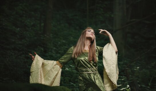 Fată frumoasă îmbrăcată într-o rochie de zână stă în pădure