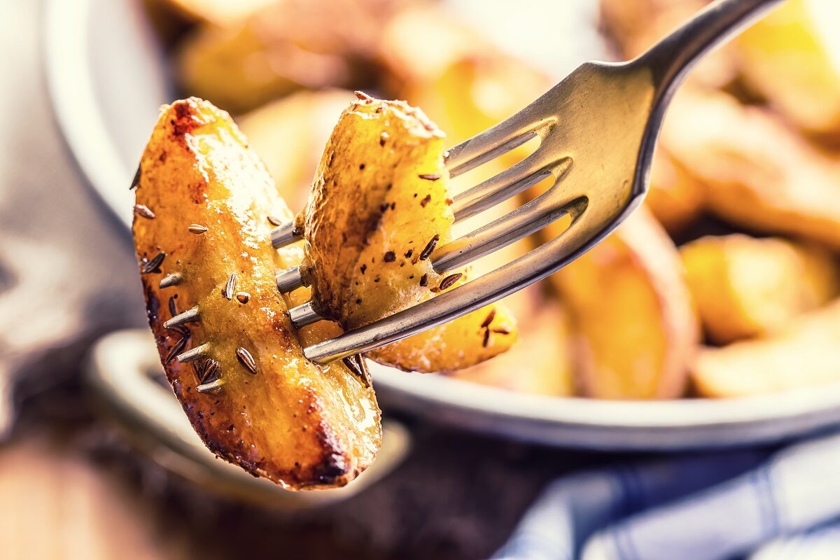 O furculiță cu un cartof copt pentru a ilustra ce se întâmplă în corpul tău dacă mănânci cartofi