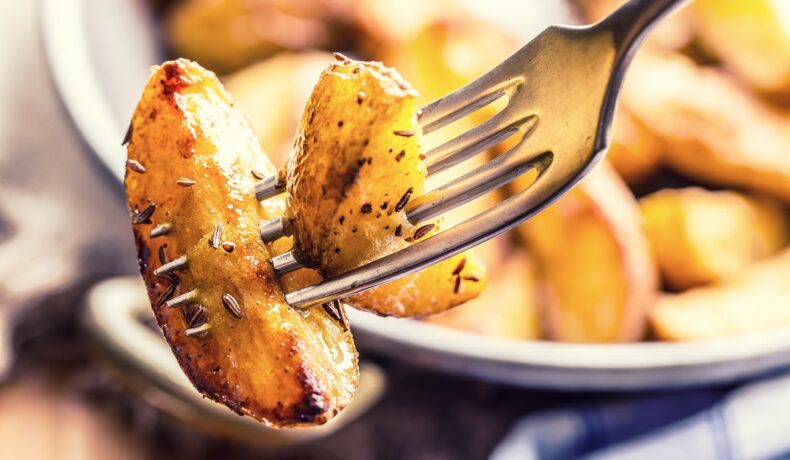 O furculiță cu un cartof copt pentru a ilustra ce se întâmplă în corpul tău dacă mănânci cartofi