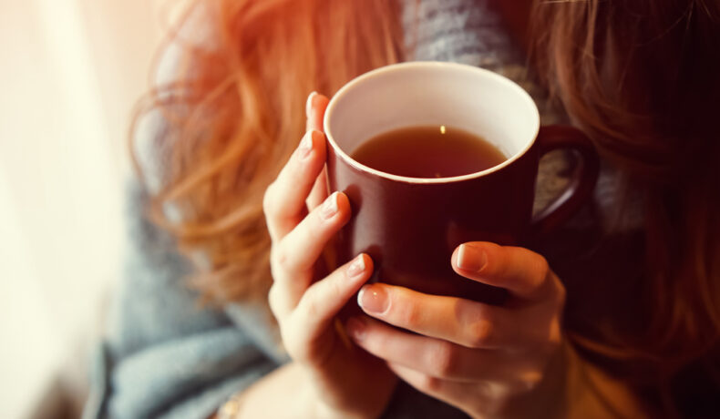 O femeie care bea ceai dintr-o cană