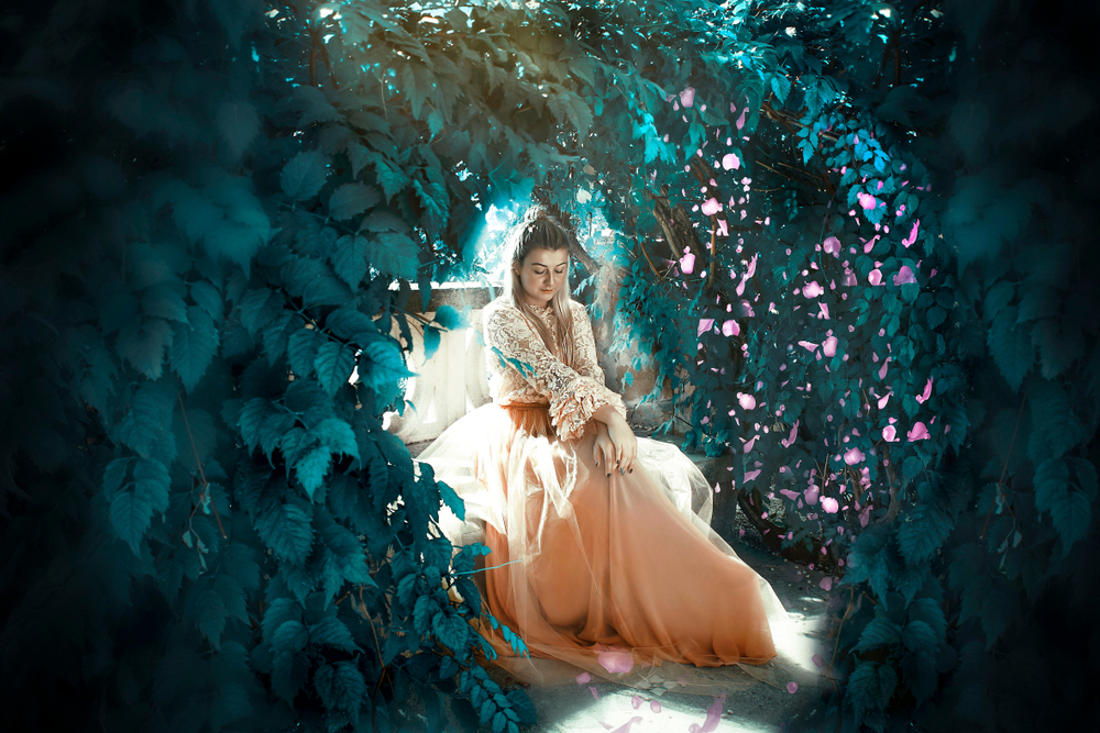 Fată frumoasă îmbrăcată într-o rochie lungă stă în pădure