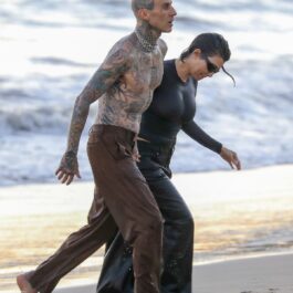 Kourtney Kardashian și Travis Barker în timp ce ies împreună din ocean