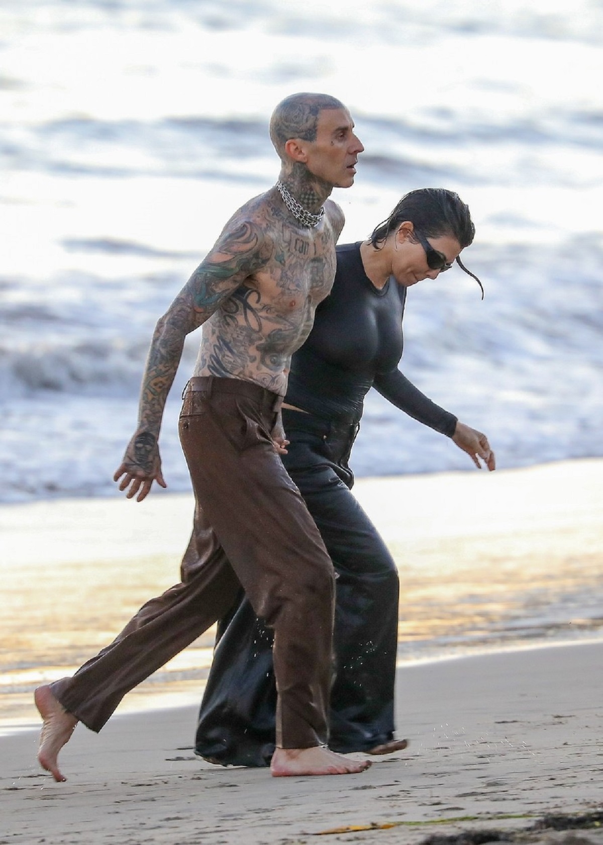 Kourtney Kardashian și Travis Barker în timp ce ies împreună din ocean