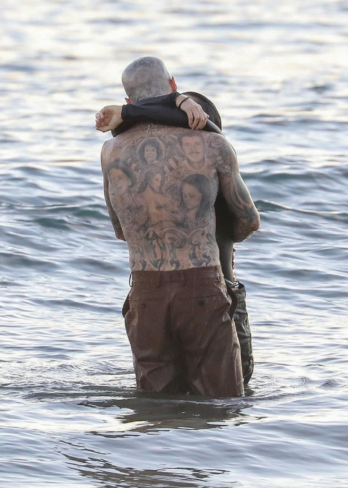 Kourtney Kardashian și Travis Barker în timp ce se sărută în apa oceanului
