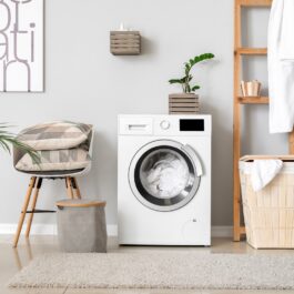 O mașină de spălat alături de un coș de rufe pentru a ilustra principalele lucuri pe care nu știai că le poți curăța la mașina de spălat