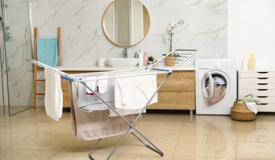 O încăpere aerisită în care se află un uscător de haine și o mașină de spălat rufe pentru a ilustra cum poți să-ți usuci hainele mai rapid iarna