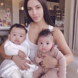 Kim Kardashian, nemachiată, cu doi copii în brațe