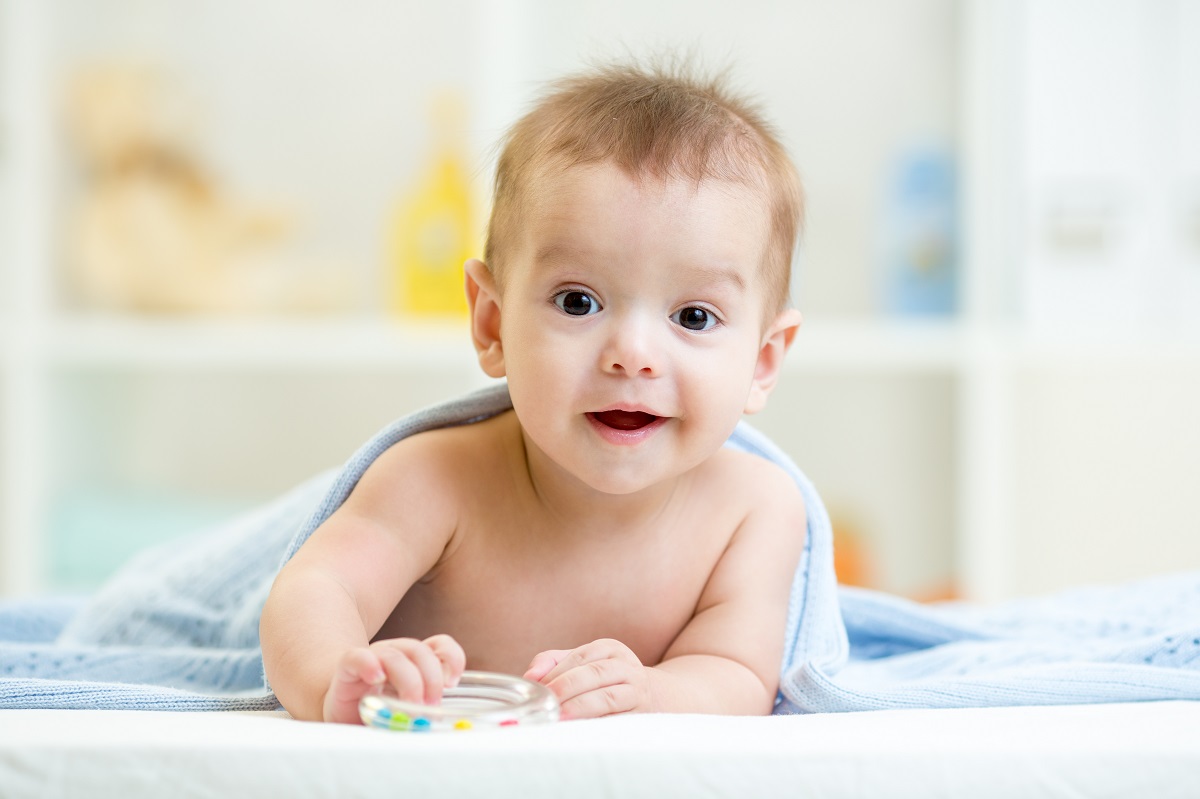 Un bebeluș care stă pe o păturică albă pentru a ilustra ce nume de bebeluși sunt interzise în cinci state din SUA