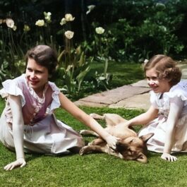 Prințesa Elisabeta alături de sora sa, Prințesa Margaret, în timp ce se joacă cu un câine