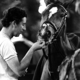 Prințul Charles alături de un cal după un meci de polo