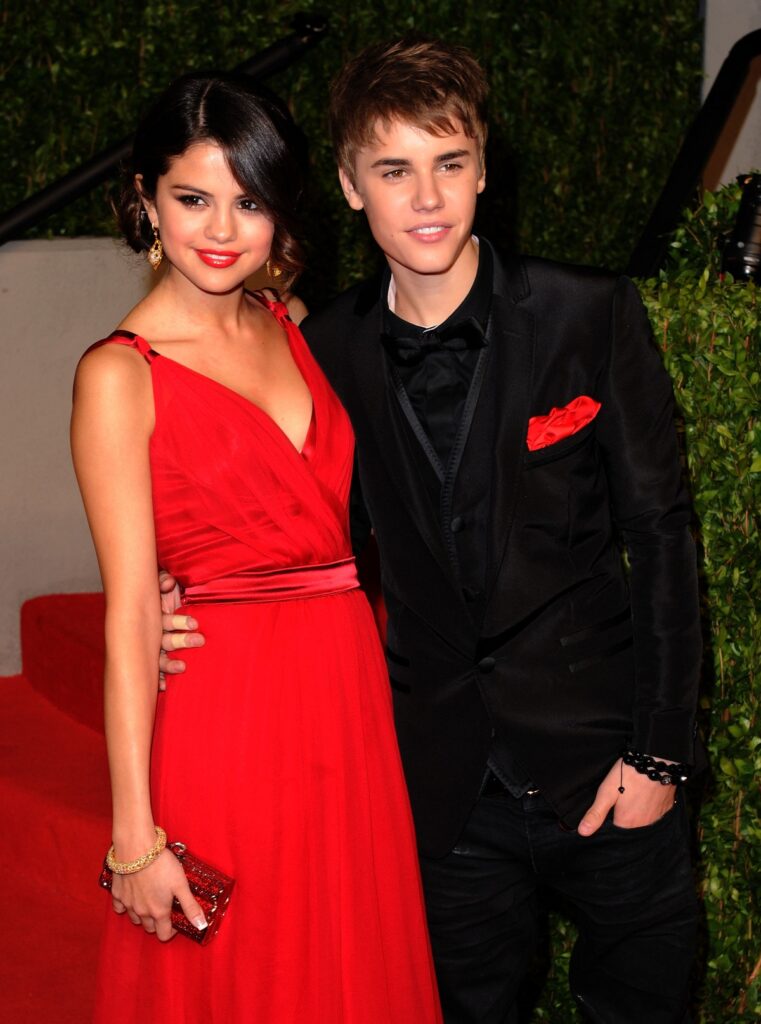 Selena Gomez într-o rochie roșie alături de Justin Bieber, la costum, la Gala Vanity Fair din 2011
