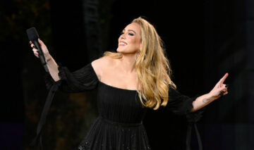 Adele, într-o rochie neagră, fotografiată pe scenă