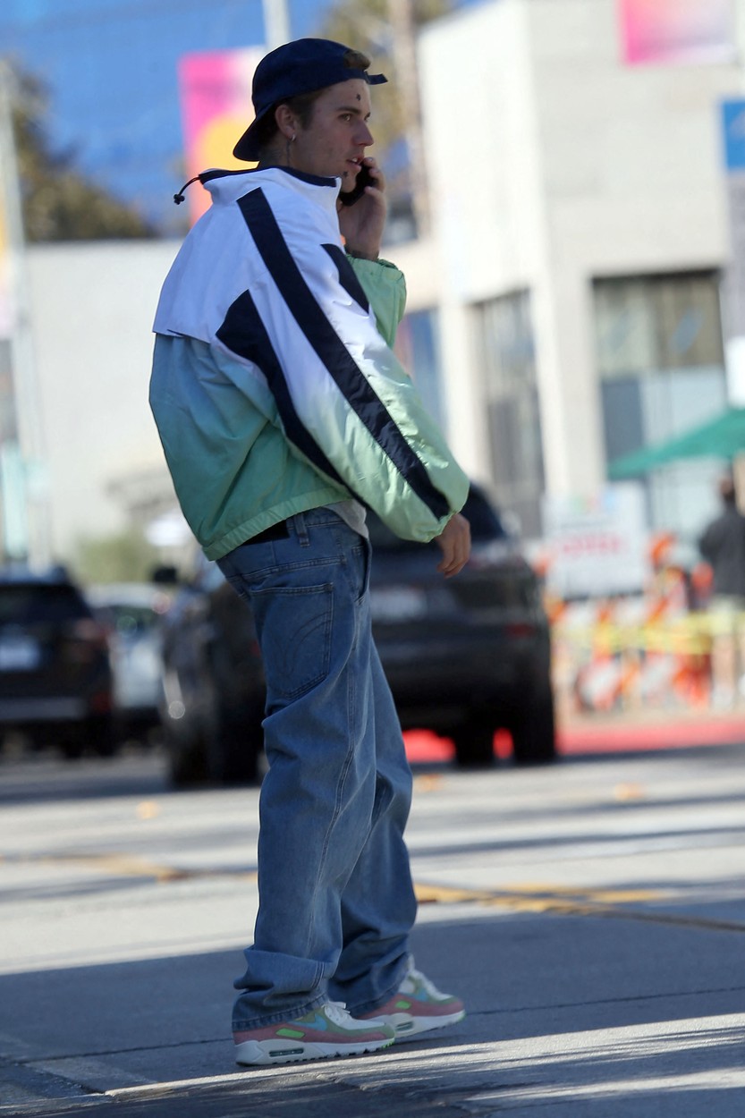 Justin Bieber, în haine sport, vorbește la telefon pe stradă