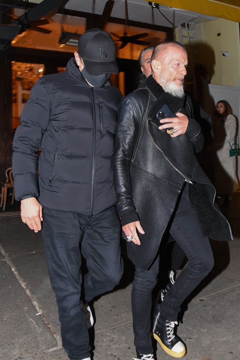 Leonardo DiCaprio, îmbrăcat în negru, însoțit de un asistent, la un restaurant din New York