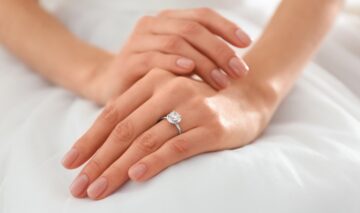 O femeie care își arată inelul de logodnă pentru a ilustra motivul pentru care inelul de logodnă se poartă pe degetul inelar