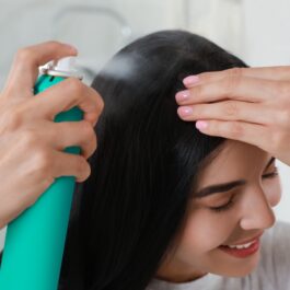 O femeie care aplică șampon uscat pe păr