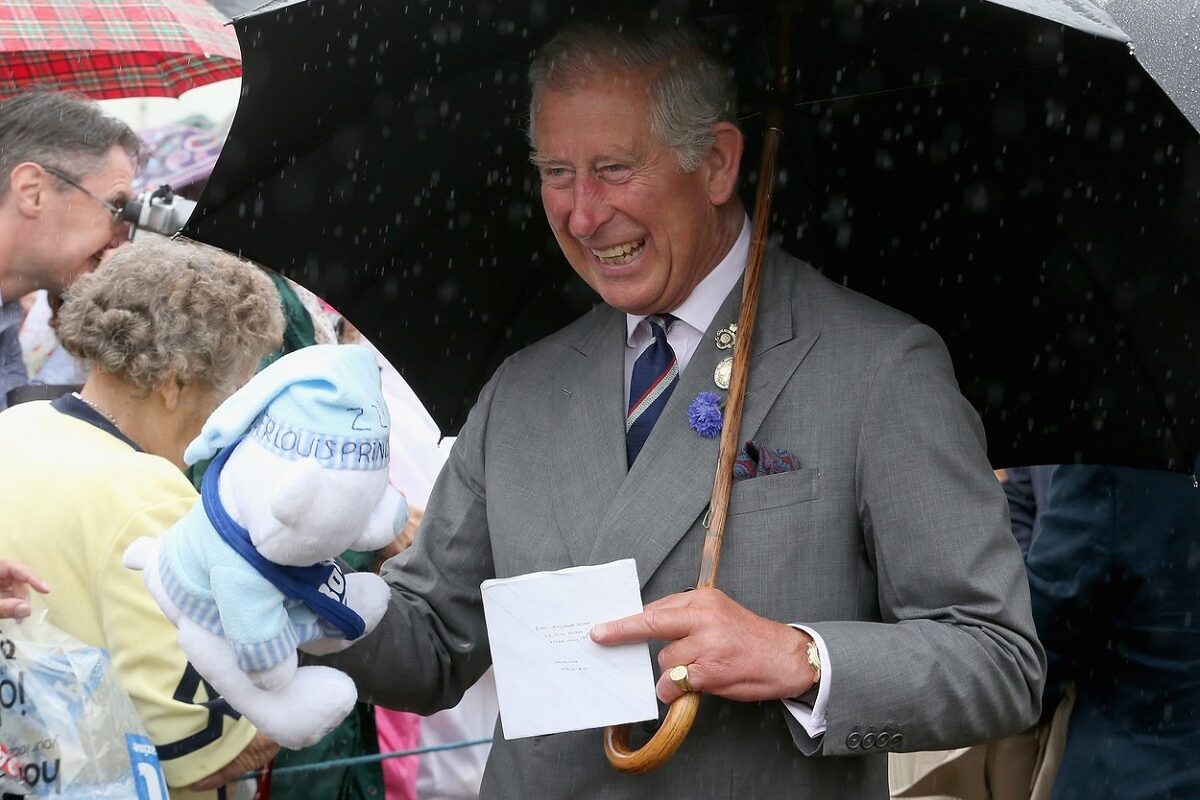 Regele Charles cu un ursuleț de pluș în brațe la o întâlnire publică