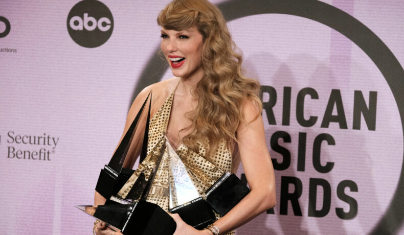 Taylor Swift, la American Music Awards 2022, cu brațele pline de premii, într-o rochie aurie