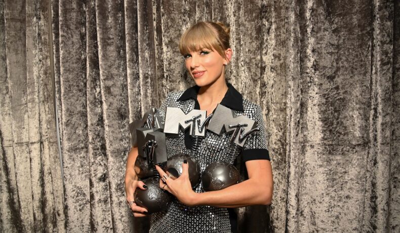 Taylor Swift ținând în brațe mai multe premii de lla MTV EMAs 2022