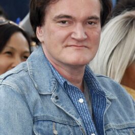 Quentin Tarantino într-o cămașă albastră în timp ce este pozat la un eveniment public, fiind pe lista de vedete care împlinesc 60 de ani în 2023