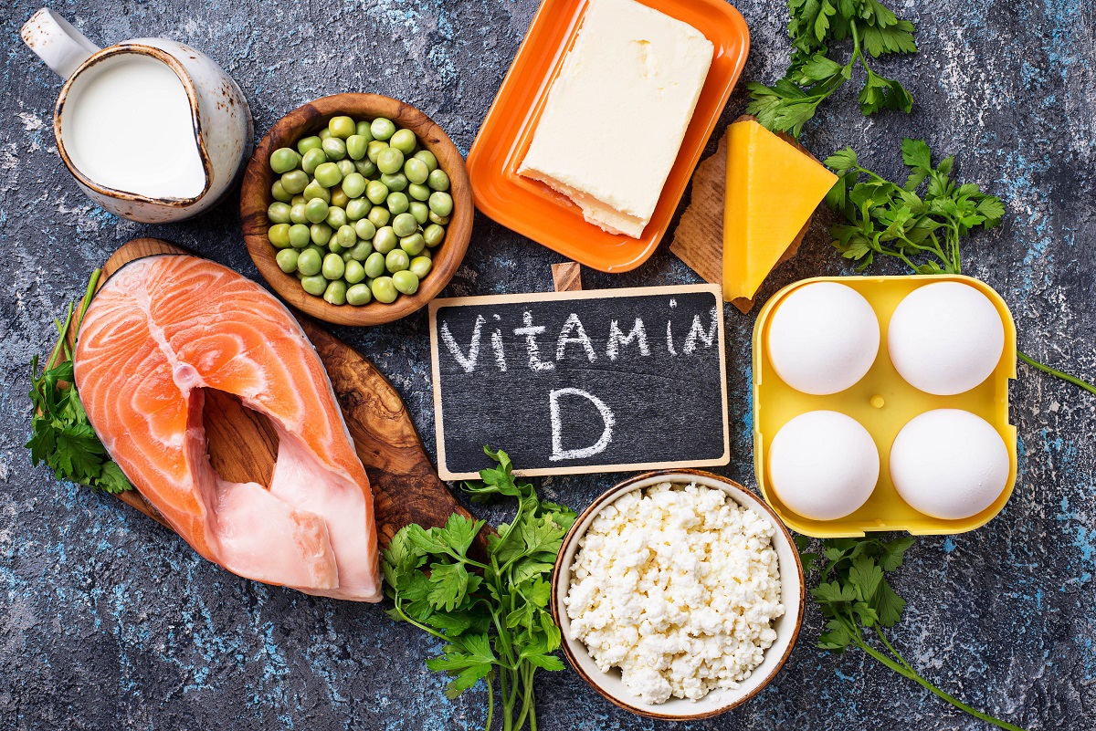 Mai multe alimente bogate în vitamina D sunt așezate pe un platou gri