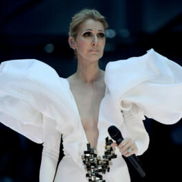 Celine Dion, într-o rochie albă, cu umeri bufanți, cu decolteu amplu