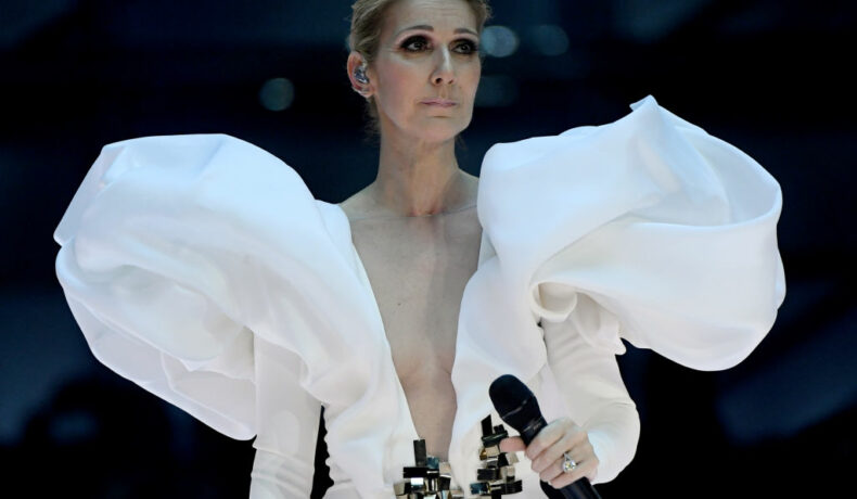 Celine Dion, într-o rochie albă, cu umeri bufanți, cu decolteu amplu