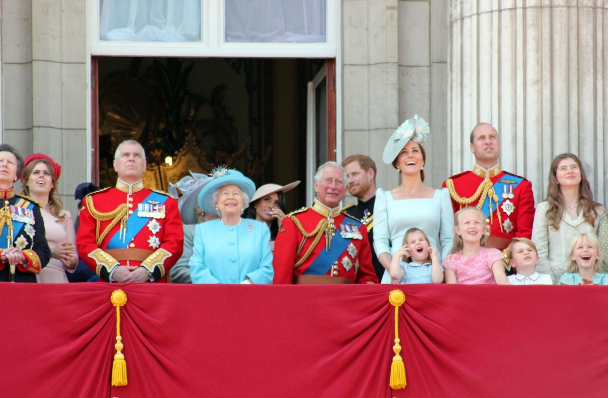 Familia Regală se află în balconul regal, îmbrăcați în haine festive și uniforme roșii